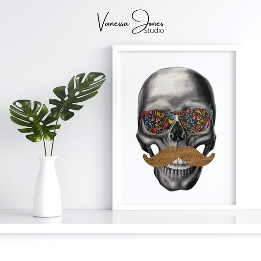 Large canvas art on a white background. The drawing is in a white frame and features a black and white charcoal skull, wearing sunglasses in a vibrant floral pattern and a cork mustache in a classic shape. To the left of the art piece is a white vase holding two green leaf stems.